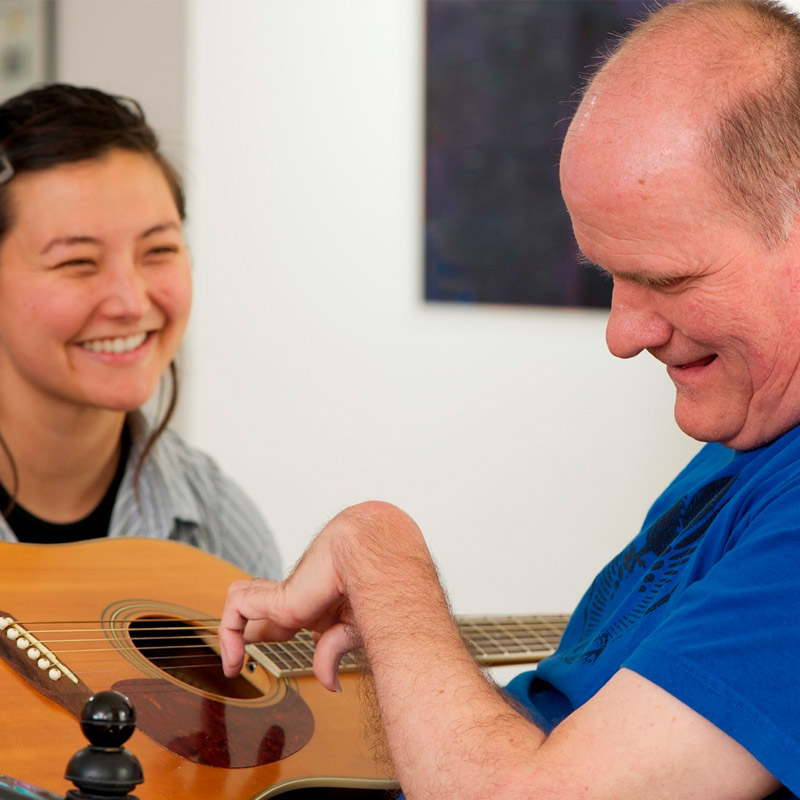 adults with disability playing guitar